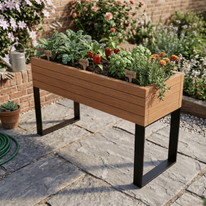 A waist-high wooden elevated garden bed on a stone patio featuring kale, peppers, and basil with herb markers.